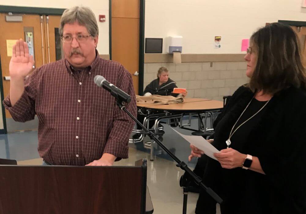 Tom Weiner takes the oath of office, administered by Char Latronica,  Monday night as the newest member of the board at Lyons School District 103. (Photo by Steve Metsch)