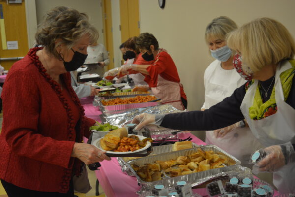 Residents being served a meal catered by Rocco Vino's Italian Restaurant at Orland Township's February Luncheon.