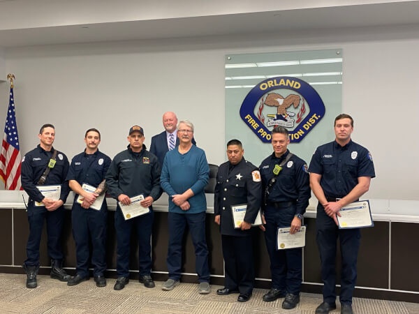 Cardiac Arrest survivor Kenneth Wilkas (front 4th from left) poses with some of the fire and police officers who saved his life after he suffered a heart attack on November 26, 2022. OFPD Board President John Brudnak (backrow). Photo courtesy of the Orland Fire Protection District