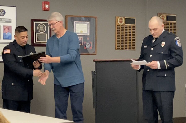 Cardiac Arrest survivor Kenneth Wilkas thanks Orland Park Police Officer Julio Oliva as OFPD EMS Director Lt. Josh Girdick reads the names of firefighter/paramedics who were honored also. Photo courtesy of the Orland Fire Protection District