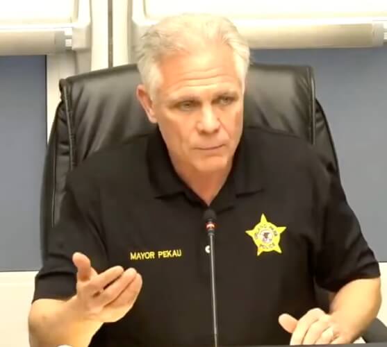 Orland Park Mayor Keith Pekau wears a "Police" badge on his shirt during his political attacks made from his taxpayer funded village pulpit.