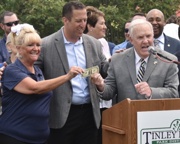 Jim Garrett, president CEO of Chicago Southland Convention & Visitors Bureau, donates $1 to buy the site to park board president Marie Ryan and Sen. Hastings