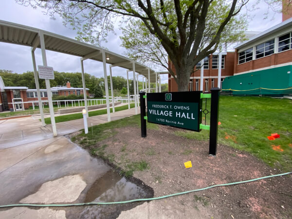 Mayor Keith Pekau returnd the Owens Village Hall sign but put it behind the building on Monday, May 6, 2024. The sign had been removed in February with no explanation. Pekau returned it only after public outcry. Photo courtesy of Ray Hanania