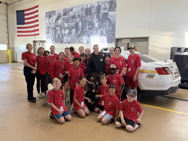 Orland Fire Protection District Kids Camp attendees June 2026 pose with Cook County Canine Unit dog Darwin. Photo Ray Hanania